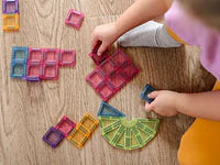 Criança a construir e explorar peças magnéticas eliFIX no chão.
